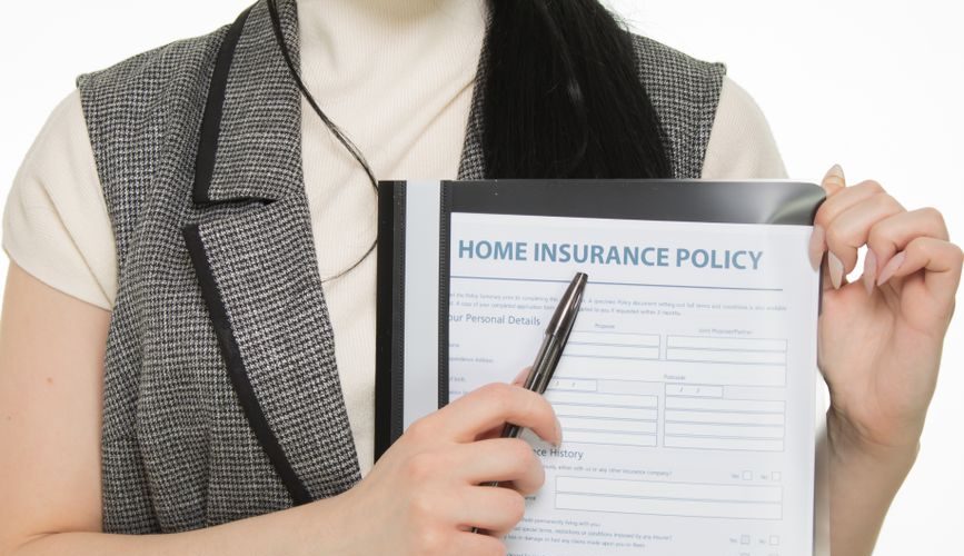 Homeowner reviewing home insurance policy document related to new siding upgrade