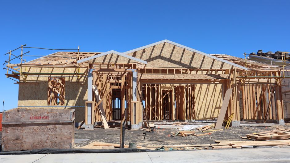 Close-up of weather resistive barrier stapled to wood sheathing during siding prep