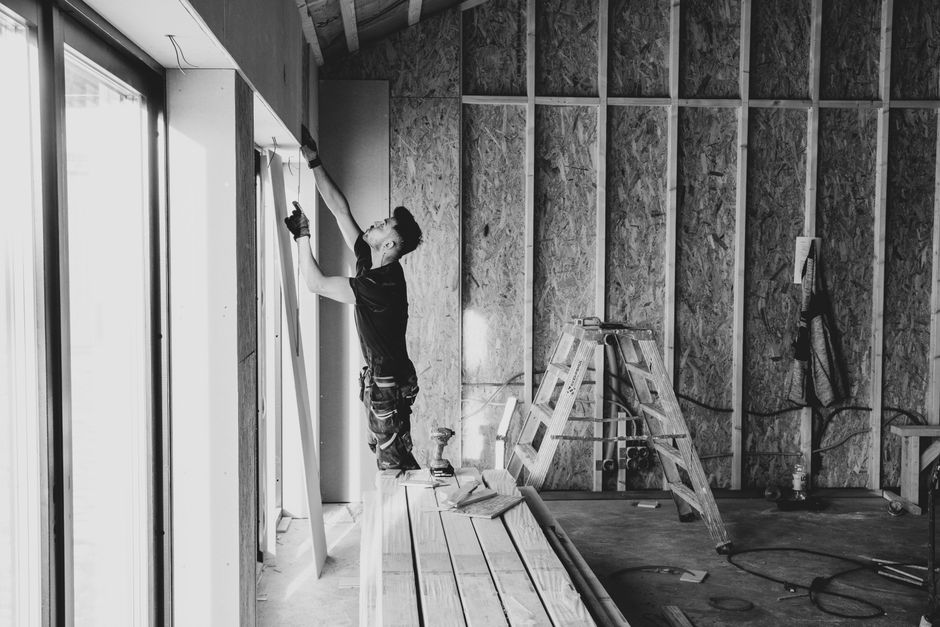 Roll of house wrap moisture barrier being installed under siding